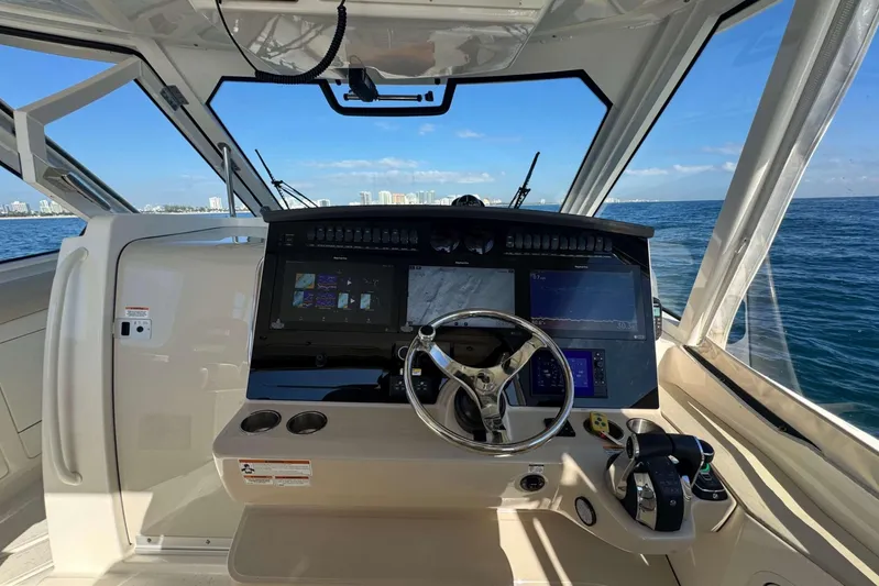 True Story Yacht Photos Pics 2022 Boston Whaler 380 Realm helm with advanced navigation system, steering wheel, and ocean view.