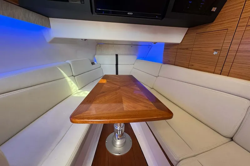 True Story Yacht Photos Pics Interior of 2022 Boston Whaler 380 Realm with elegant seating and wooden table.