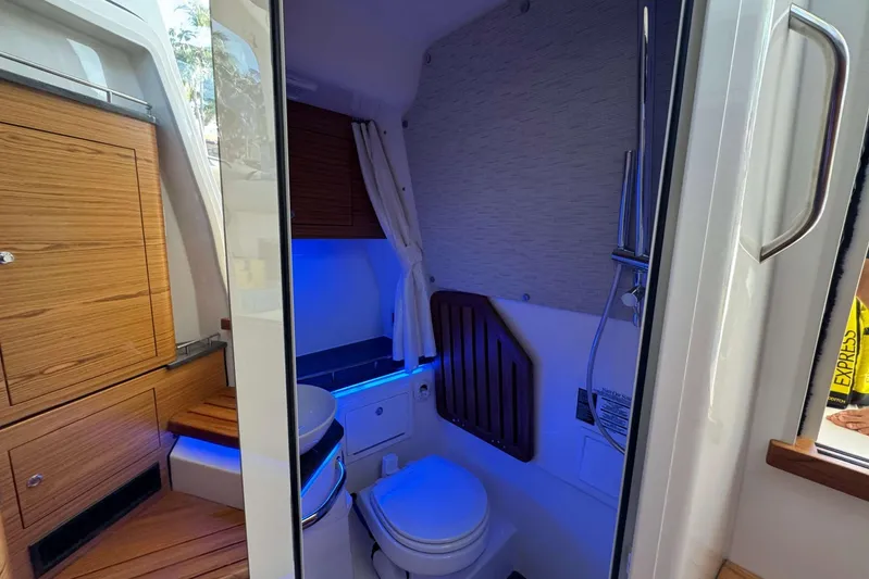 True Story Yacht Photos Pics Interior of 2022 Boston Whaler 380 Realm boat, featuring a compact bathroom with wooden cabinetry.