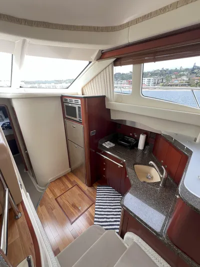 Viva La Vida Yacht Photos Pics 2006 Sea Ray 44 Sedan Bridge interior with kitchenette, wood flooring, and scenic window view.