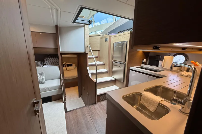 On My Way Yacht Photos Pics Luxurious interior of 2018 Beneteau Gran Turismo 50 yacht with modern kitchen and cozy seating area.