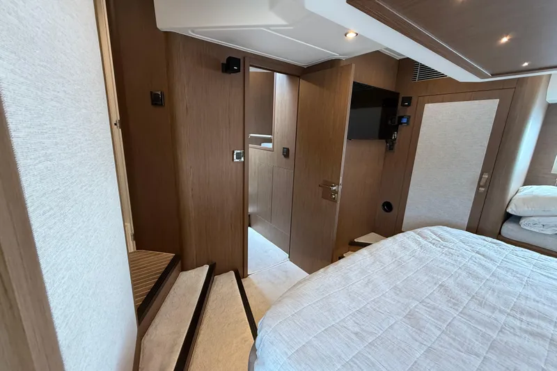 On My Way Yacht Photos Pics Luxurious interior of 2018 Beneteau Gran Turismo 50 yacht, featuring elegant wood finishes and cozy bedding.