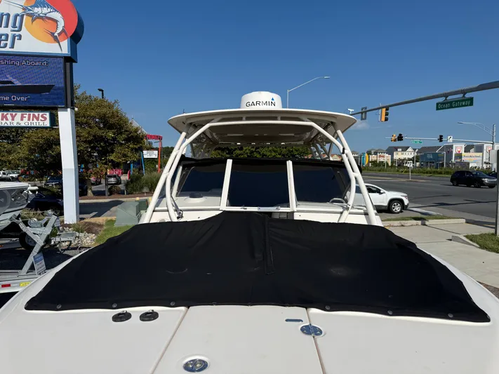  Yacht Photos Pics 2018 Grady-White Freedom 275 boat with Garmin equipment, parked near a busy street.