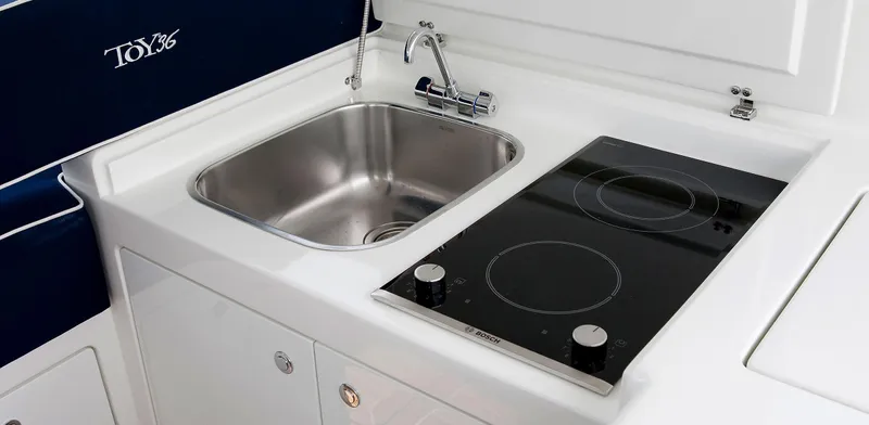  Yacht Photos Pics Modern kitchen area in Toy 36 model, featuring a sink and electric cooktop, 2025 design.