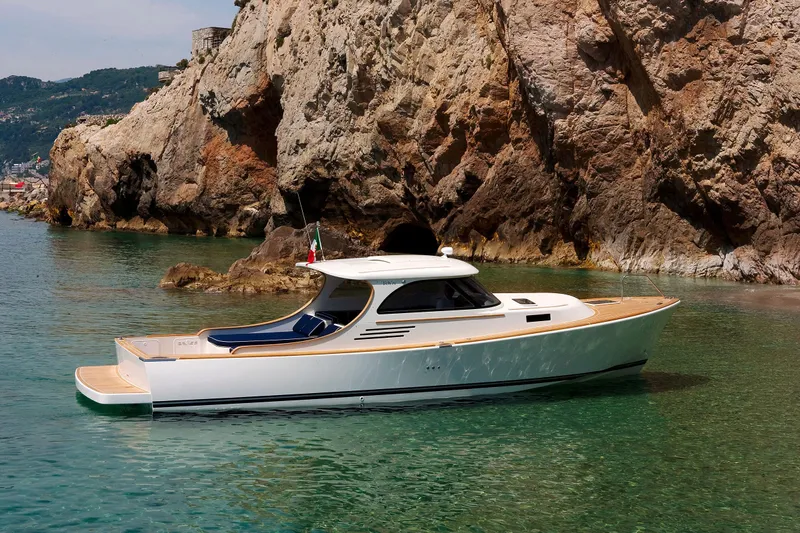  Yacht Photos Pics Luxurious Toy 36 yacht, 2025 model, cruising near rocky coastline in clear turquoise waters.