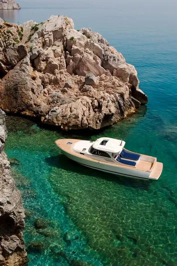  Yacht Photos Pics Luxury boat near rocky coastline in clear turquoise water, Toy 36 model, 2025.