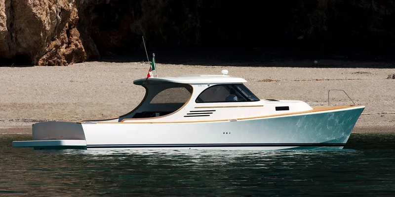  Yacht Photos Pics Modern Toy 36 yacht, 2025 model, anchored near a rocky shoreline.