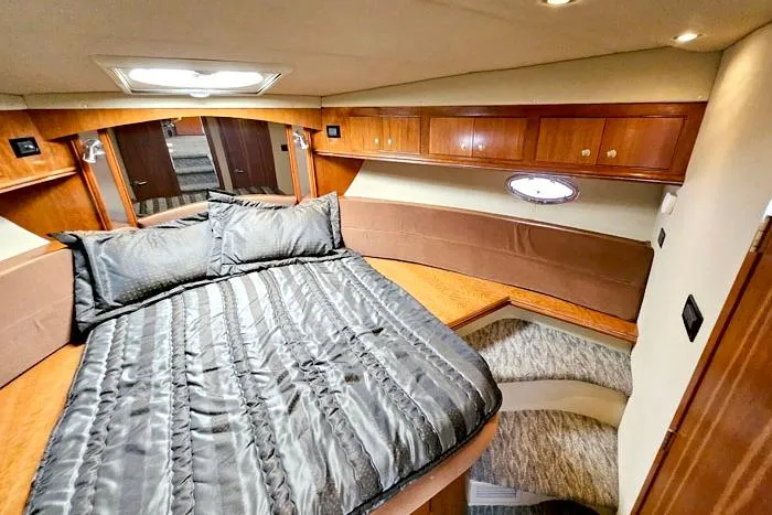 Yacht Photos Pics Luxurious 2006 Cruisers Yachts 455 Express Motoryacht cabin with elegant bedding and wood accents.