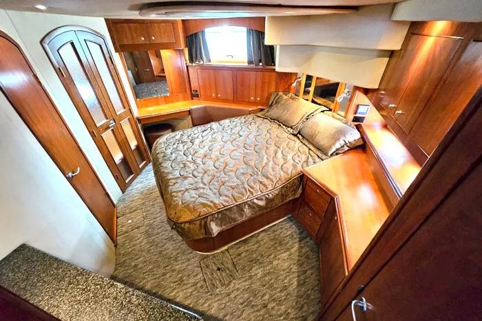  Yacht Photos Pics Luxurious 2006 Cruisers Yachts 455 Express Motoryacht bedroom with elegant wood finishes.