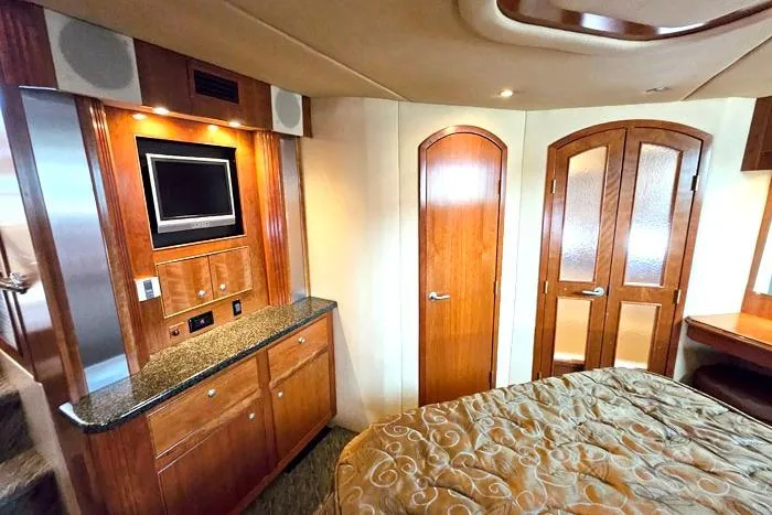  Yacht Photos Pics Luxurious 2006 Cruisers Yachts 455 Express Motoryacht interior with wood cabinetry and TV.