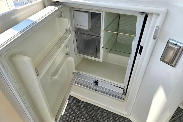 Yacht Photos Pics Open refrigerator on 2006 Cruisers Yachts 455 Express Motoryacht, showing shelves and door storage.