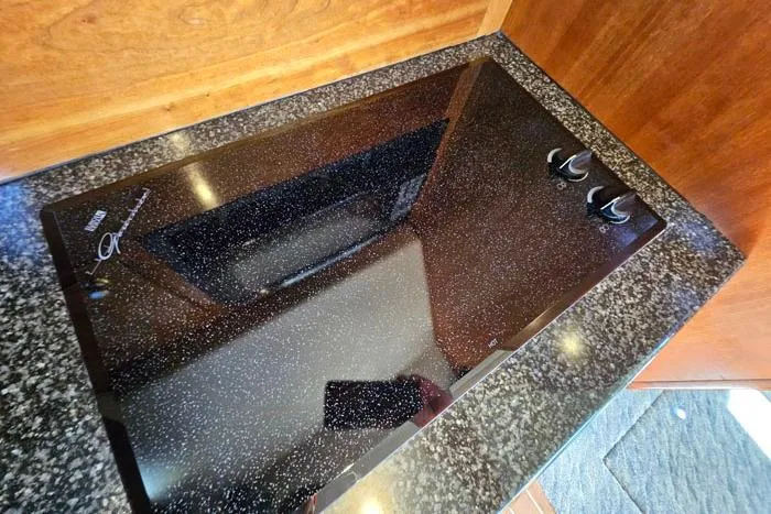  Yacht Photos Pics 2006 Cruisers Yachts 455 Express Motoryacht kitchen with sleek black cooktop.