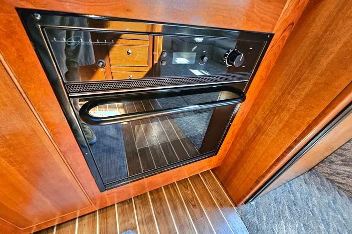  Yacht Photos Pics 2006 Cruisers Yachts 455 Express Motoryacht interior with built-in oven and wood paneling.