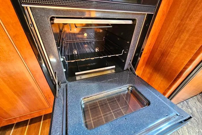  Yacht Photos Pics Open oven in 2006 Cruisers Yachts 455 Express Motoryacht kitchen, showcasing interior and wooden cabinetry.