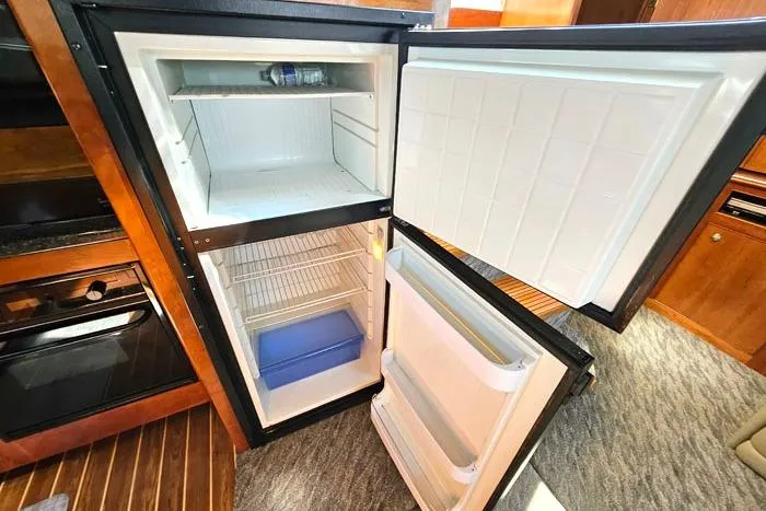 Yacht Photos Pics Open refrigerator inside 2006 Cruisers Yachts 455 Express Motoryacht, showcasing spacious interior.