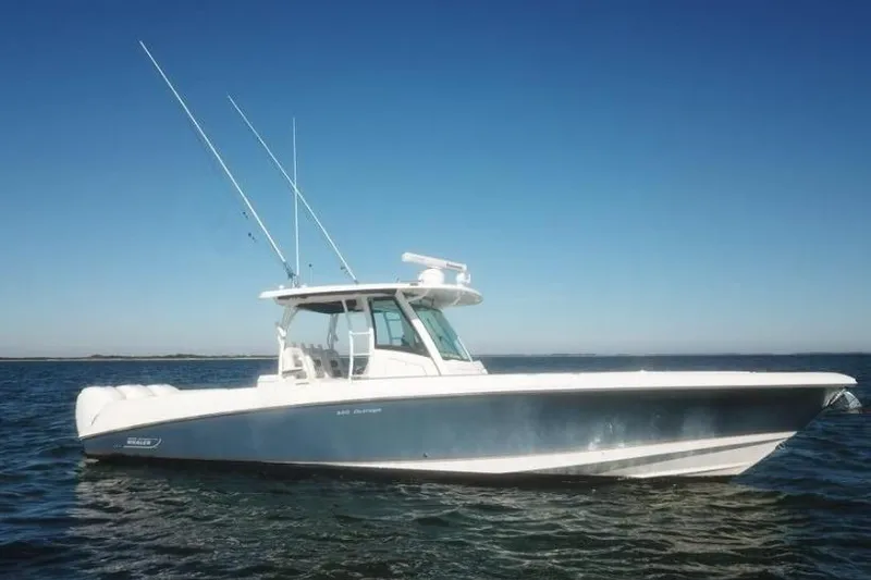  Yacht Photos Pics 2014 Boston Whaler 350 Outrage boat on calm water under clear blue sky.
