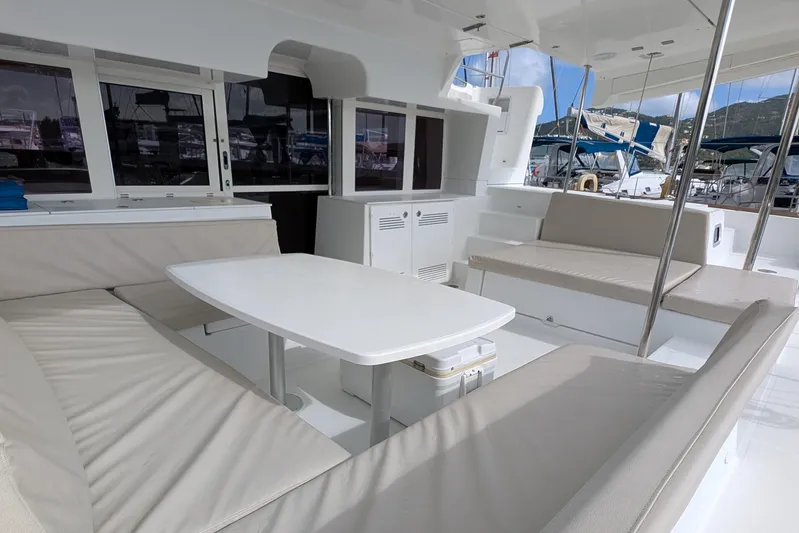  Yacht Photos Pics Spacious seating area on a 2015 Lagoon 450 catamaran, featuring comfortable cushions and a white table.