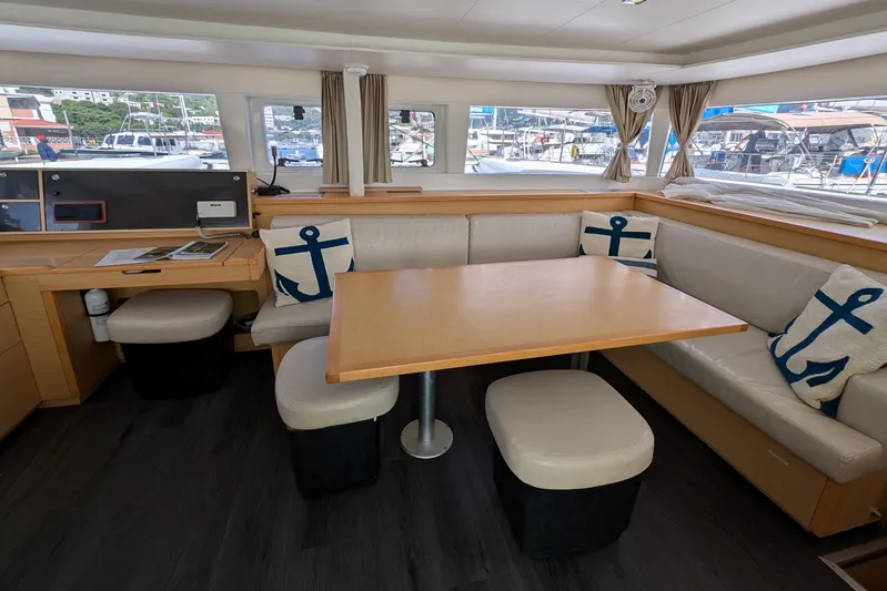  Yacht Photos Pics Interior of 2015 Lagoon 450 catamaran with dining area, anchor-themed cushions, and marina view.