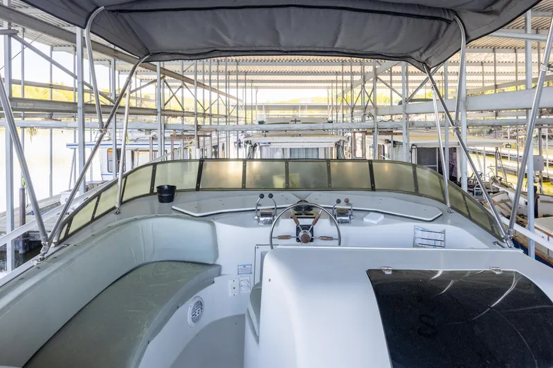  Yacht Photos Pics 1990 Bluewater Yachts 55 Yacht interior, featuring helm and seating under a canopy.