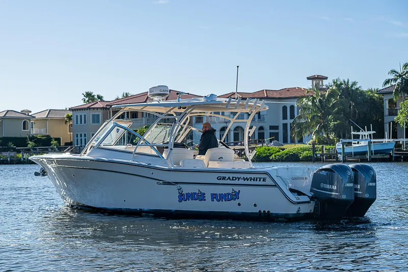 Sundae Funday Yacht Photos Pics 2017 Grady-White Freedom 307 boat cruising on a sunny waterfront.