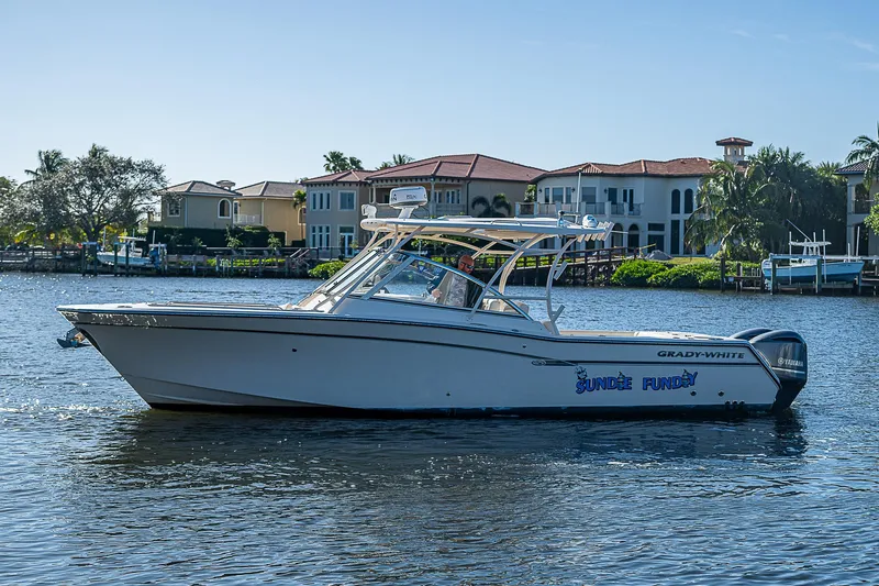 Sundae Funday Yacht Photos Pics 2017 Grady-White Freedom 307 boat on water, with waterfront homes in the background.