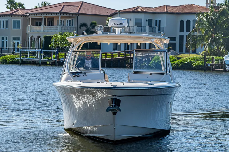 Sundae Funday Yacht Photos Pics 2017 Grady-White Freedom 307 boat cruising on a sunny waterfront near luxury homes.