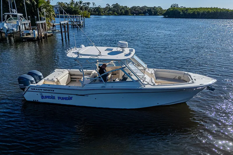 Sundae Funday Yacht Photos Pics 2017 Grady-White Freedom 307 boat on calm water, surrounded by lush greenery.
