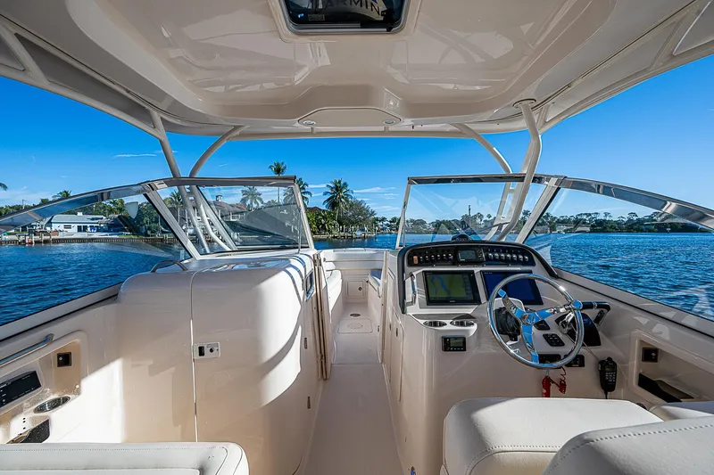 Sundae Funday Yacht Photos Pics 2017 Grady-White Freedom 307 boat interior with steering wheel, dashboard, and open water view.