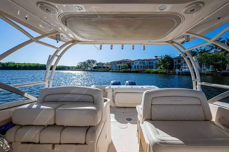 Sundae Funday Yacht Photos Pics 2017 Grady-White Freedom 307 boat interior with luxurious seating, overlooking serene waterfront homes.