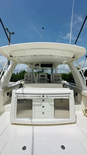 Twin J Yacht Photos Pics Boston Whaler 420 Outrage 2021 boat interior with seating and storage, under clear blue sky.