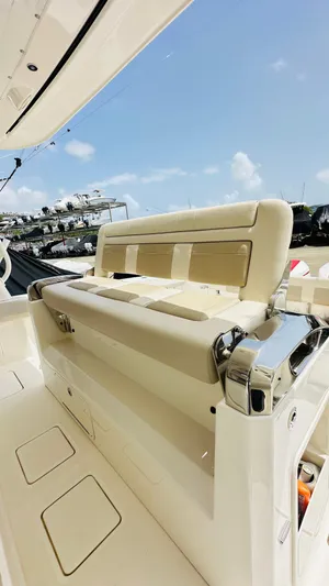 Twin J Yacht Photos Pics 2021 Boston Whaler 420 Outrage boat interior with beige seating and chrome accents under a clear sky.