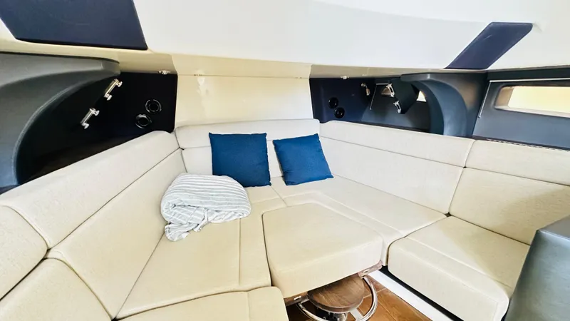 Twin J Yacht Photos Pics Interior of 2021 Boston Whaler 420 Outrage with beige seating and blue cushions.
