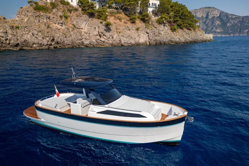  Yacht Photos Pics 2025 Apreamare GOZZO 35 yacht cruising near rocky coastline.