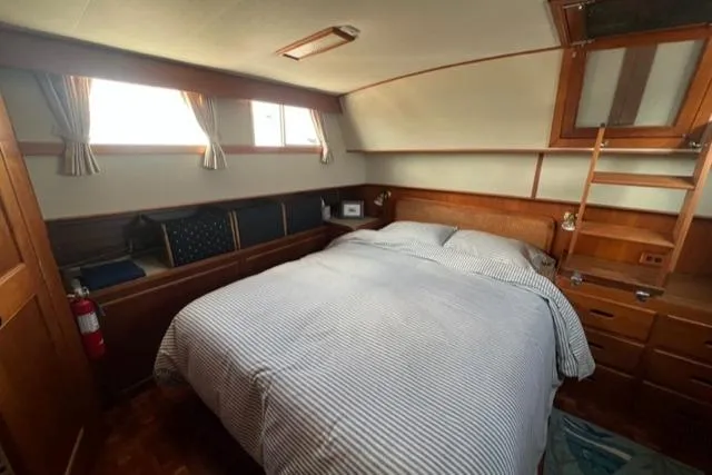 Lan Mara Yacht Photos Pics Cozy bedroom in 1987 Grand Banks 42 Classic Trawler, featuring wood accents and natural light.