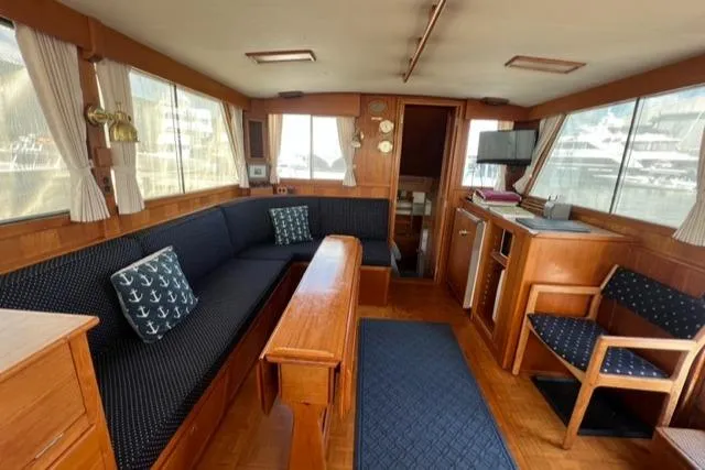 Lan Mara Yacht Photos Pics Interior of 1987 Grand Banks 42 Classic Trawler with wood furnishings and navy seating.