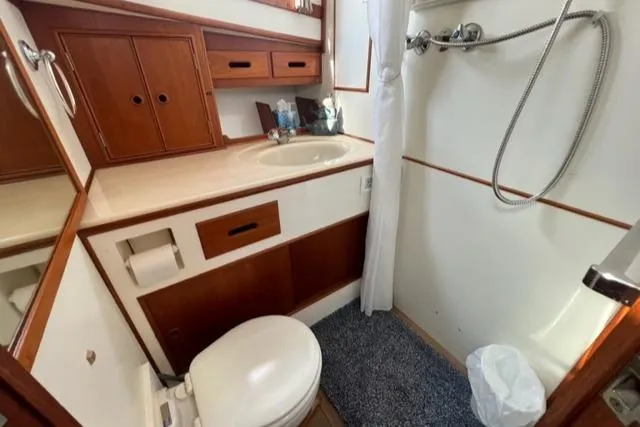 Lan Mara Yacht Photos Pics 1987 Grand Banks 42 Classic Trawler bathroom with shower, sink, and wooden cabinetry.