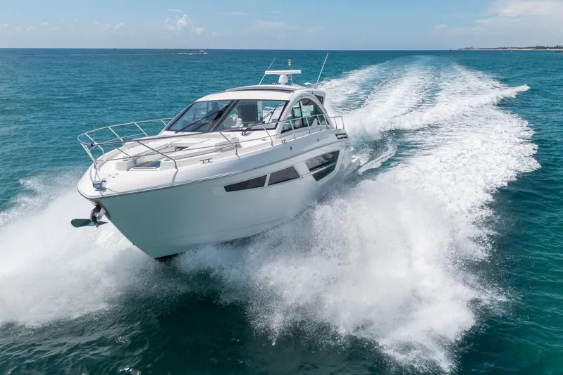 Risky Business Yacht Photos Pics 2019 Cruisers Yachts Cantius speeding on open ocean, creating dynamic water spray.