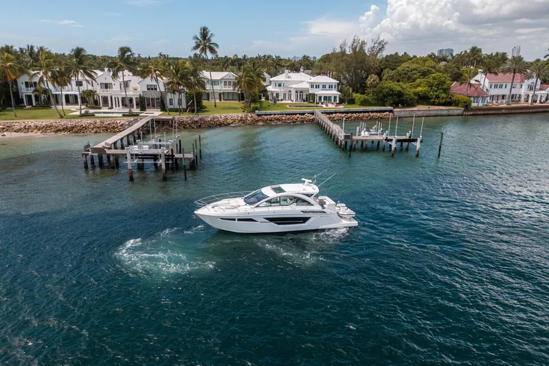 Risky Business Yacht Photos Pics 2019 Cruisers Yachts Cantius sailing near luxury waterfront homes and docks.