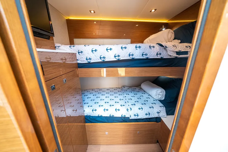 Risky Business Yacht Photos Pics 2019 Cruisers Yachts Cantius cabin with bunk beds and nautical-themed bedding.