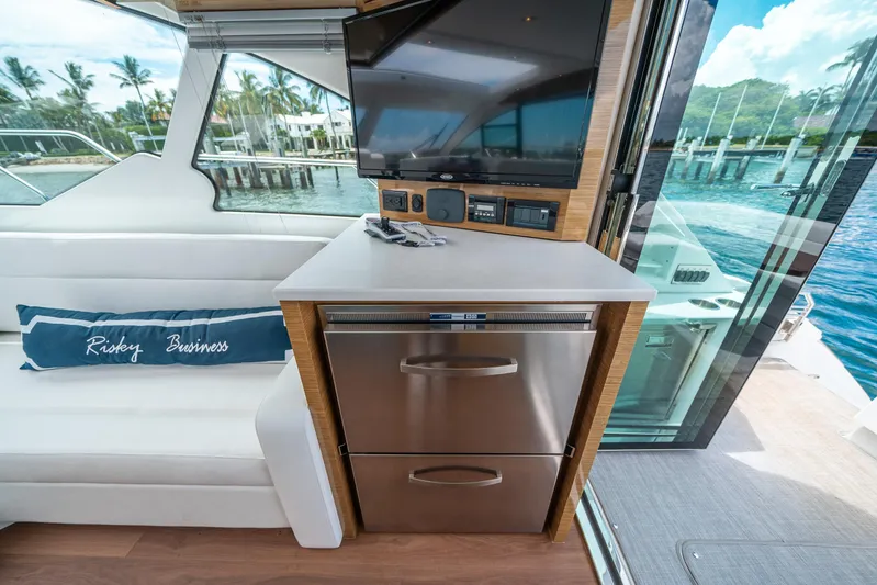 Risky Business Yacht Photos Pics 2019 Cruisers Yachts Cantius interior with modern kitchenette, TV, and scenic marina view.