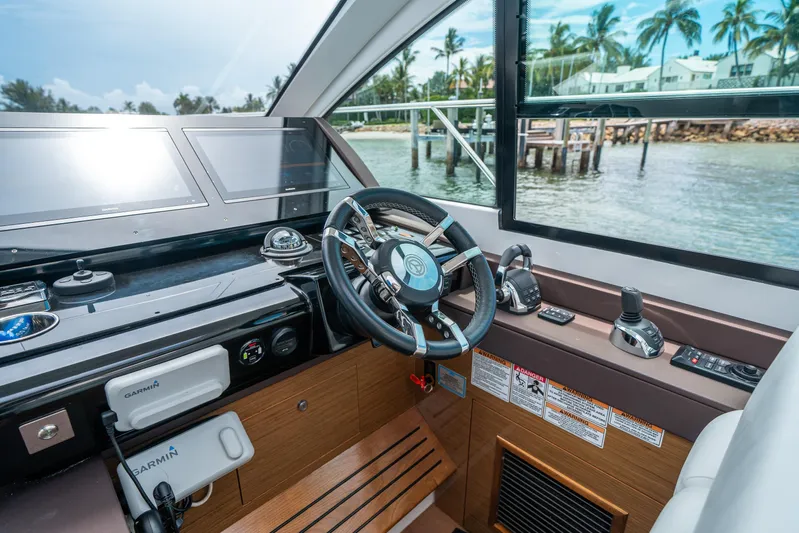 Risky Business Yacht Photos Pics 2019 Cruisers Yachts Cantius helm with advanced navigation systems and scenic waterfront view.
