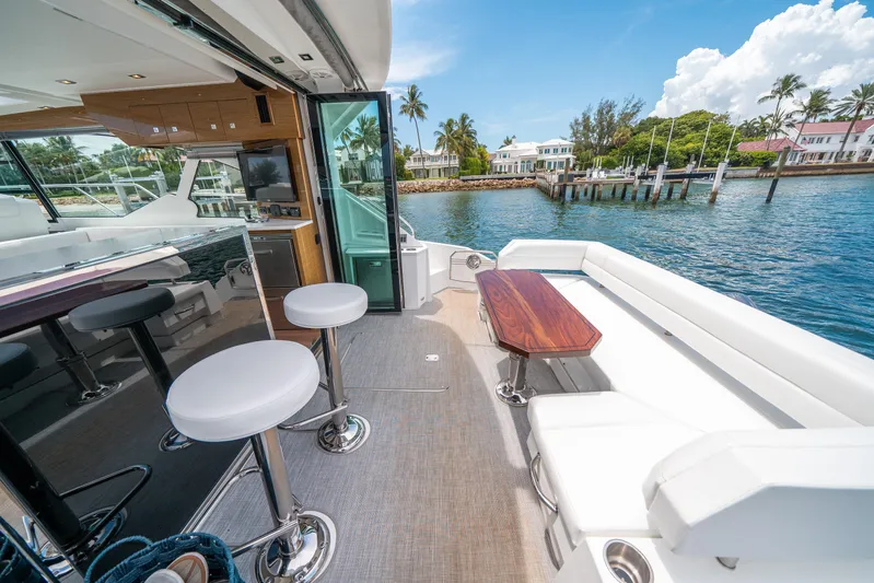 Risky Business Yacht Photos Pics Luxurious 2019 Cruisers Yachts Cantius deck with seating, bar stools, and scenic waterfront view.