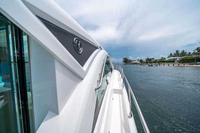 Risky Business Yacht Photos Pics 2019 Cruisers Yachts Cantius sailing on a scenic waterway under a clear sky.