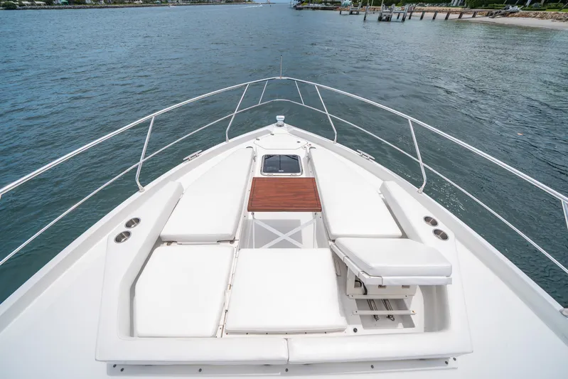 Risky Business Yacht Photos Pics 2019 Cruisers Yachts Cantius bow with white seating, wooden table, and ocean view.