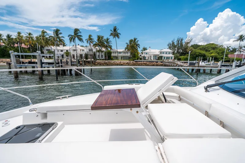 Risky Business Yacht Photos Pics Luxurious 2019 Cruisers Yachts Cantius with sun deck, docked near waterfront homes and palm trees.