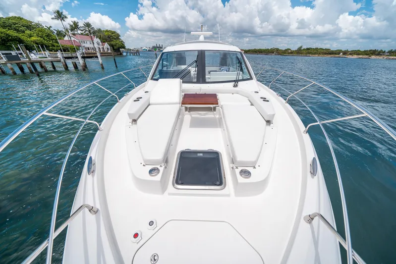 Risky Business Yacht Photos Pics 2019 Cruisers Yachts Cantius on serene water, showcasing sleek deck design and luxurious seating.