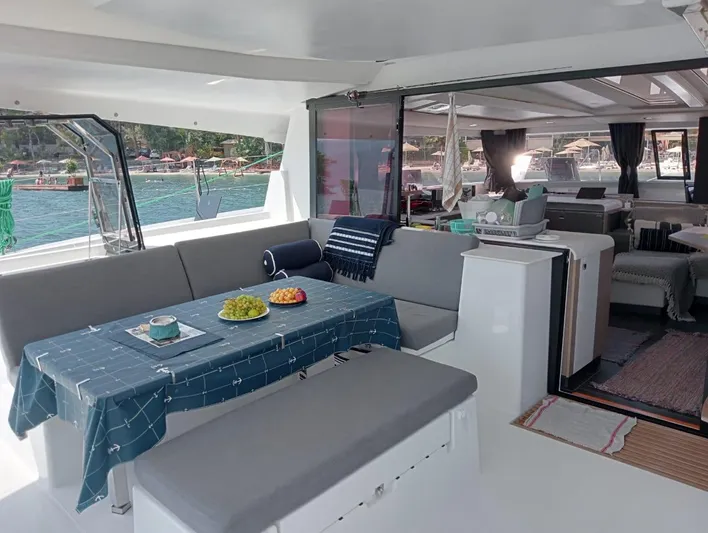  Yacht Photos Pics 2023 Fountaine Pajot Tanna 47 yacht interior with dining area and scenic ocean view.