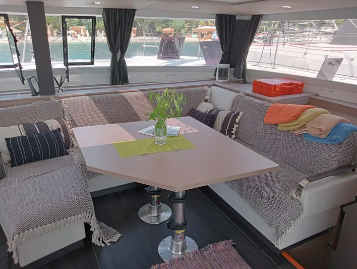  Yacht Photos Pics Interior of 2023 Fountaine Pajot Tanna 47 catamaran with cozy seating and table.