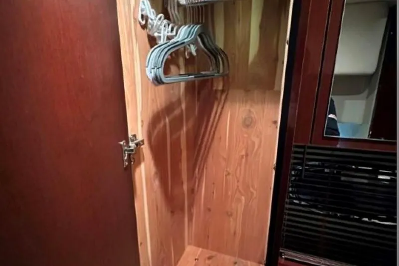  Yacht Photos Pics Wooden closet with hangers inside a 2011 Sea Ray 470 Sundancer yacht.