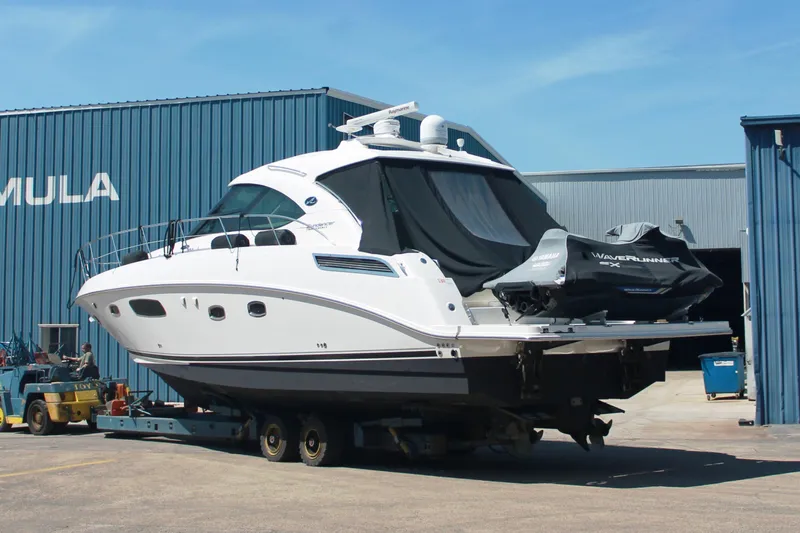  Yacht Photos Pics 2011 Sea Ray 470 Sundancer yacht on trailer outside a blue industrial building.